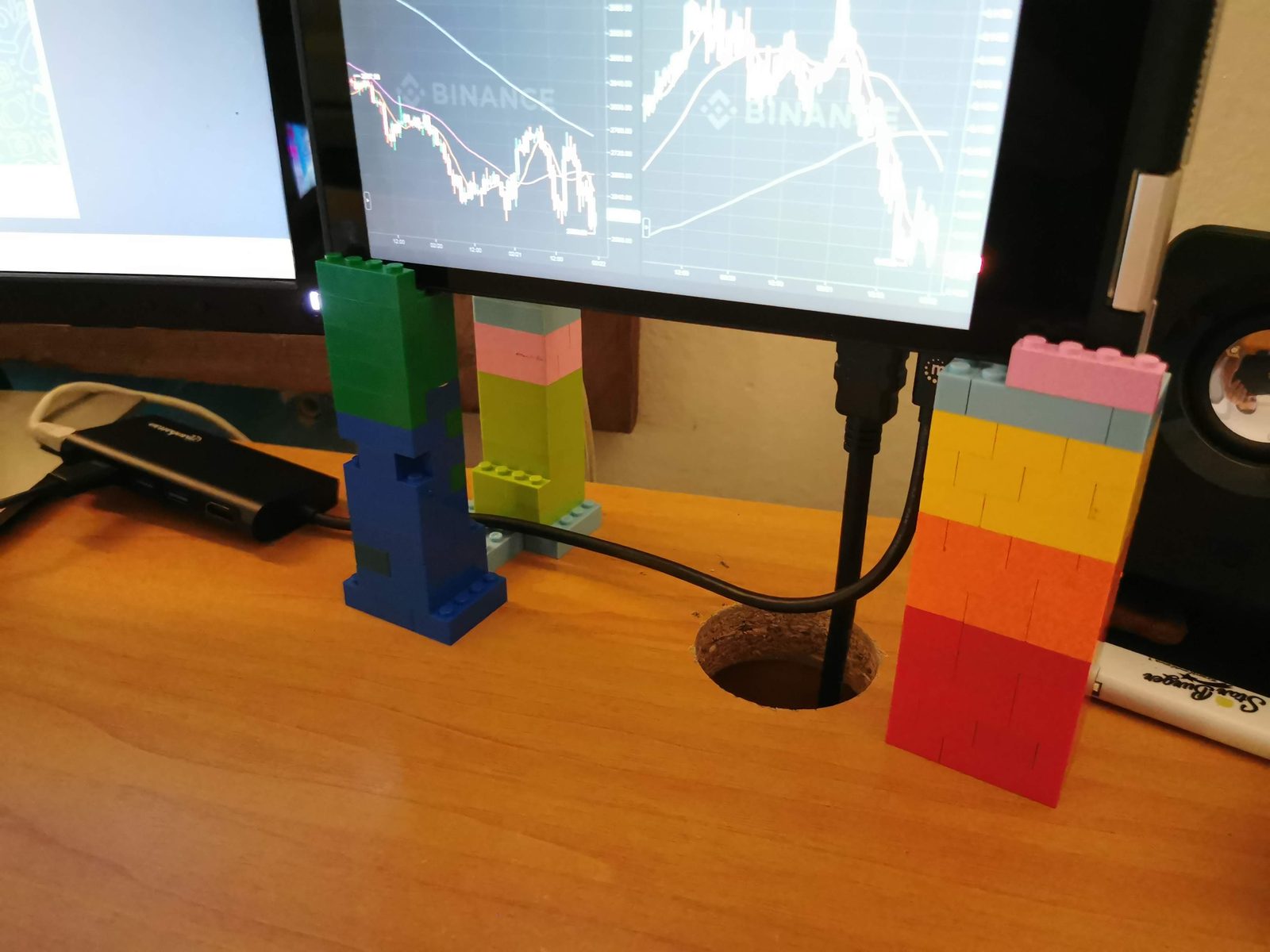 LEGO kocke poredane u tornjeve na radnom stolu uz monitor.
